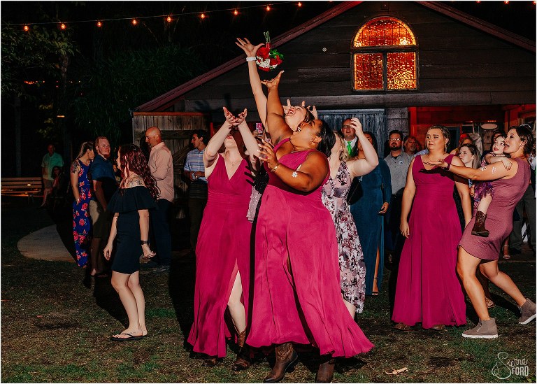 bridemaids jump for bouquet during The Acre Orlando wedding reception