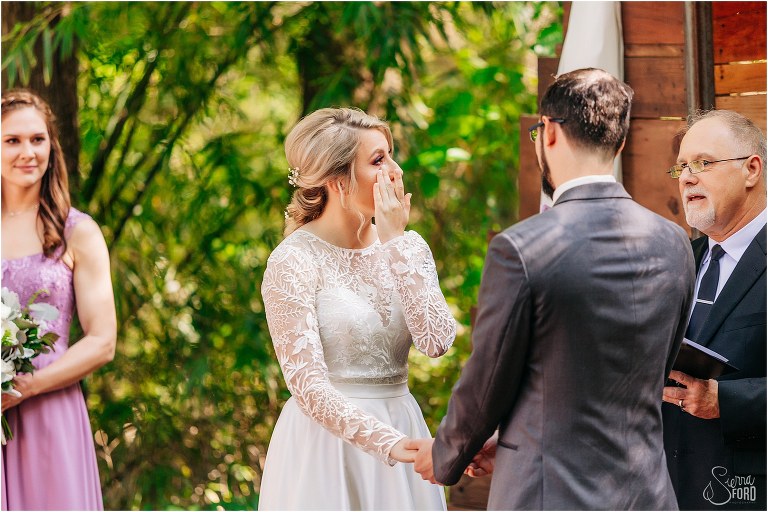 bride wipes away tear during Bridle Oaks wedding ceremony