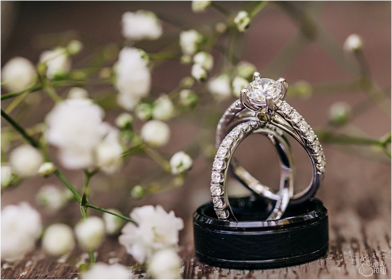 wedding bands stacked on top of each other near baby's breath at Bridle Oaks wedding