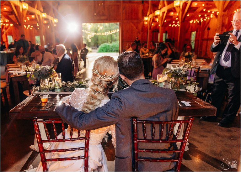 bride and groom snuggle up as they look out at their loved ones enjoying dinner at Bridle Oaks wedding
