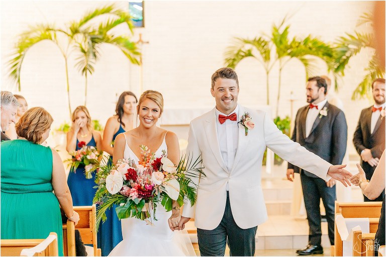 groom gets high five as they come back down aisle as husband & wife at Bayfront Lodge wedding