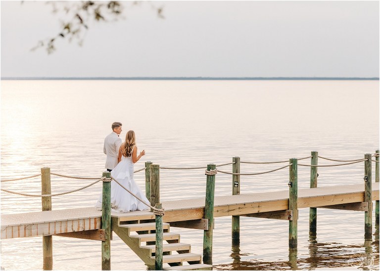 bride & groom chat as they walk down pier alone at Bayfront Lodge wedding
