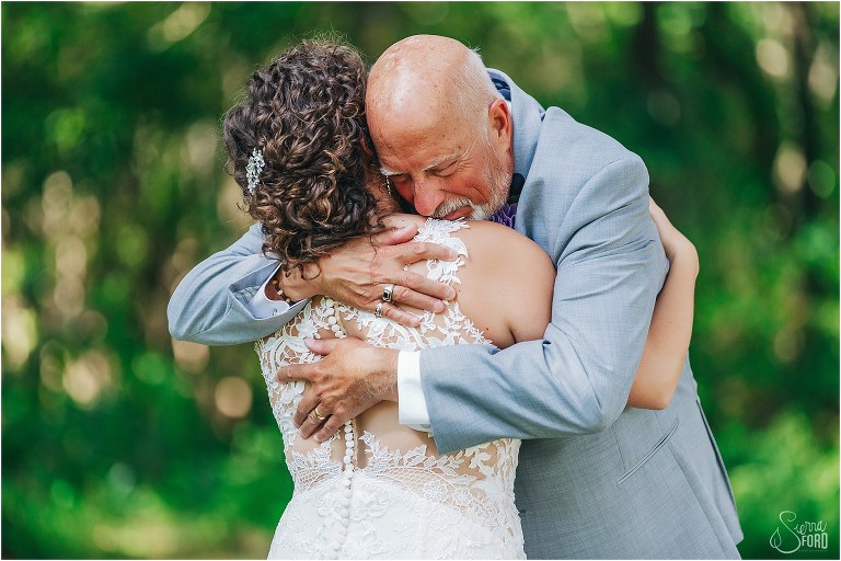 father of the bride gives bride tear-filled hug during first look at October Oaks wedding